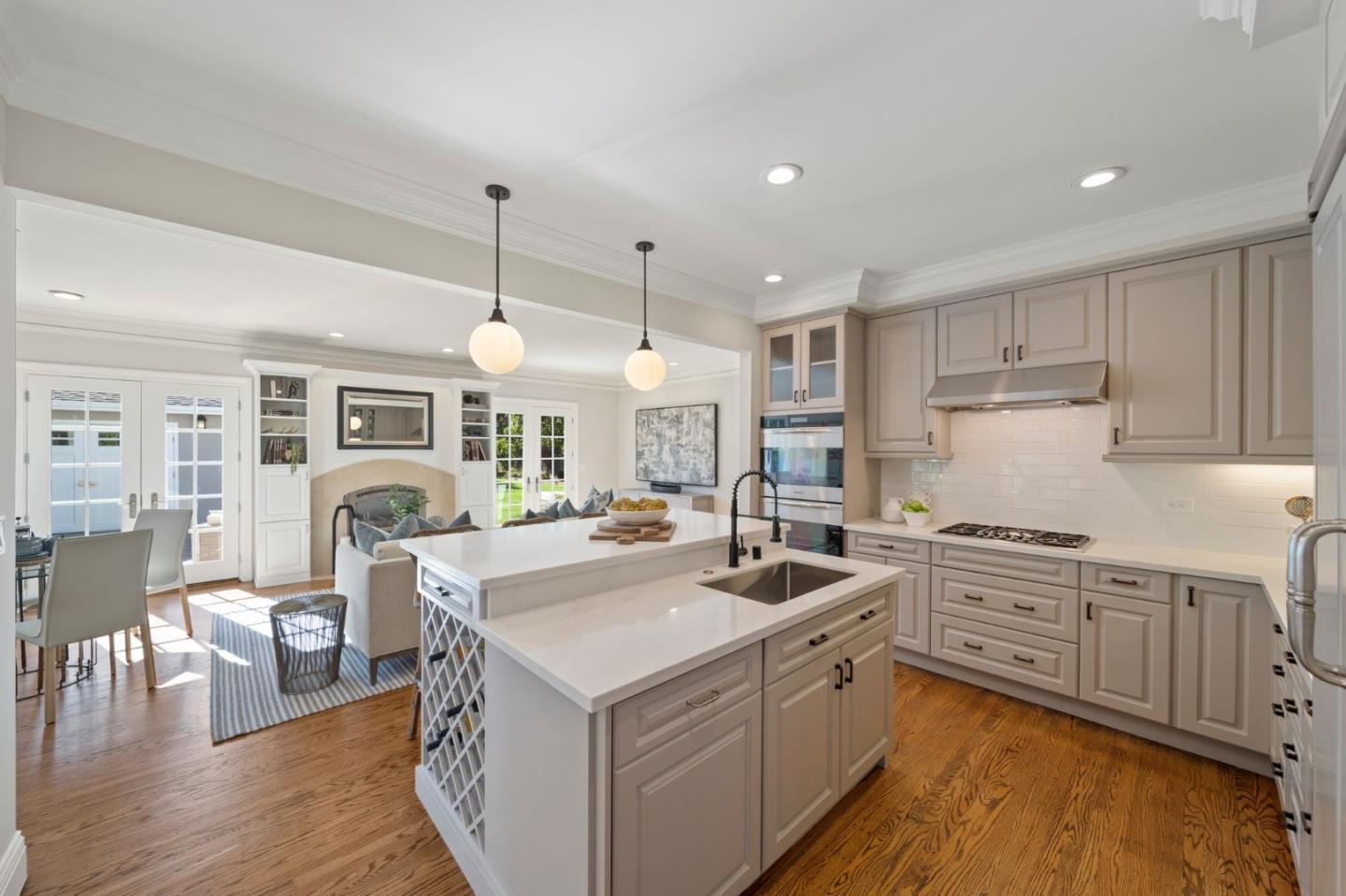 445 Hillcrest Road San Mateo, CA 94402 - Photo 9 of 41 a kitchen with a stove a sink a kitchen island with chairs and wooden floor
