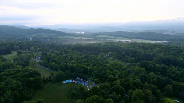 an aerial view of residential houses with outdoor space and trees