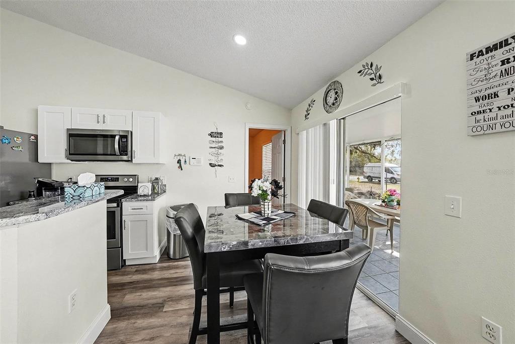 3267 Guava Lane Spring Hill, FL 34609 - Photo 12 of 30 a view of a dining room with furniture and wooden floor