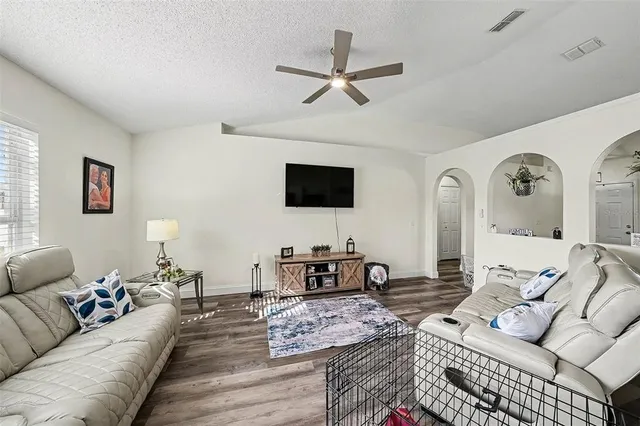 a living room with furniture a flat screen tv and a window