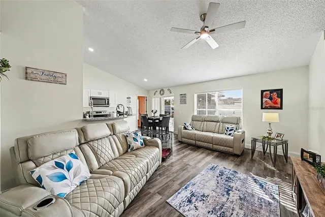 a living room with furniture and view of kitchen