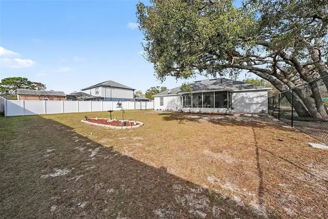 a view of a white house with a yard and sitting area