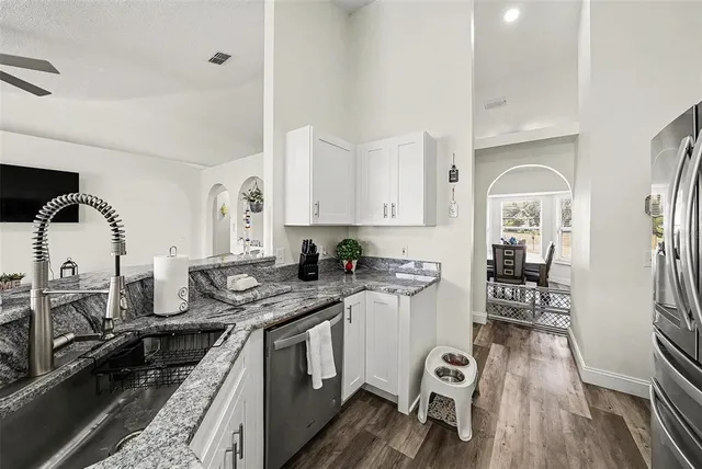 a kitchen with stainless steel appliances granite countertop a stove and a wooden floors