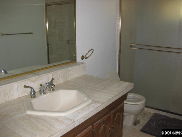 3355 Bacon Rind Road Reno, NV 89510 - Photo 6 of 9 a bathroom with a granite countertop sink a toilet and a mirror