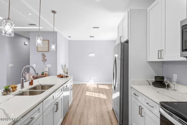 a kitchen with kitchen island white cabinets and refrigerator