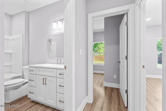 a spacious bathroom with a granite countertop toilet a sink and a mirror