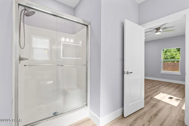 a bathroom with a glass shower door and a window
