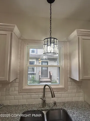 a view of a kitchen with a sink and chandelier