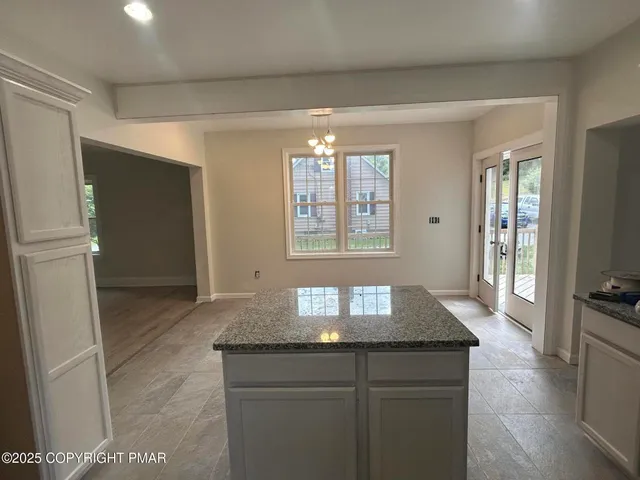 a kitchen with granite countertop a stove and refrigerator