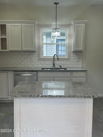 a kitchen with kitchen island granite countertop white cabinets and a counter top space