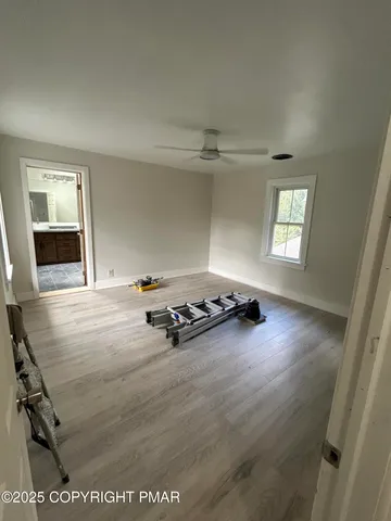 an empty room with windows and hardwood