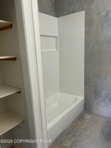 a white bath tub sitting next to a white toilet