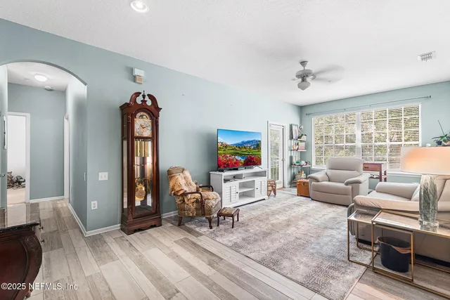 a living room with furniture a flat screen tv and a large window