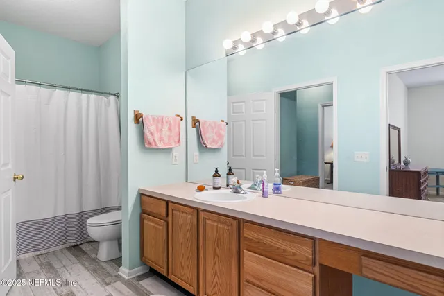 a bathroom with a double vanity sink mirror and toilet