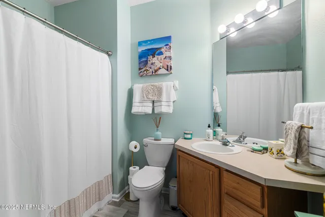 a bathroom with a sink vanity mirror and toilet