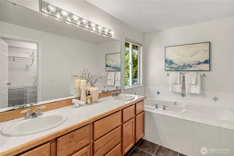 a bathroom with double vanity and a mirror