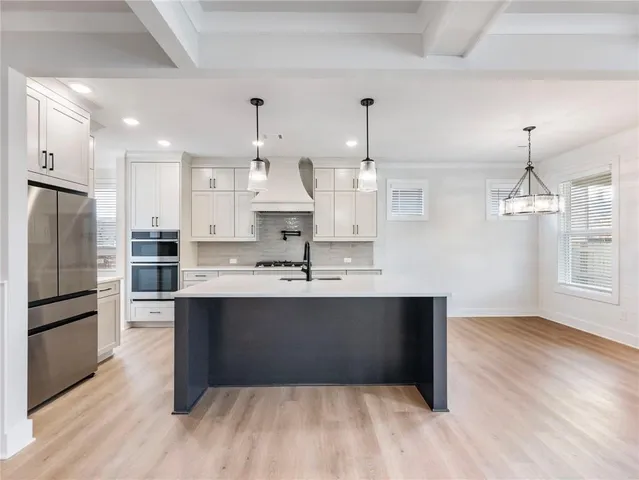 a large kitchen with kitchen island a sink stainless steel appliances and cabinets