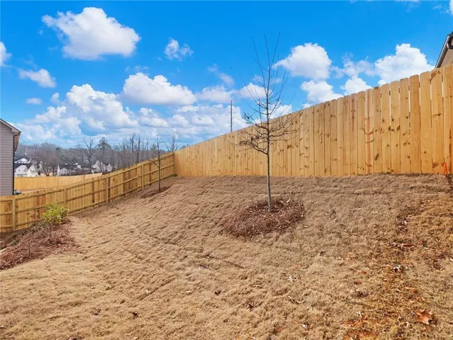a view of a house with a wooden fence