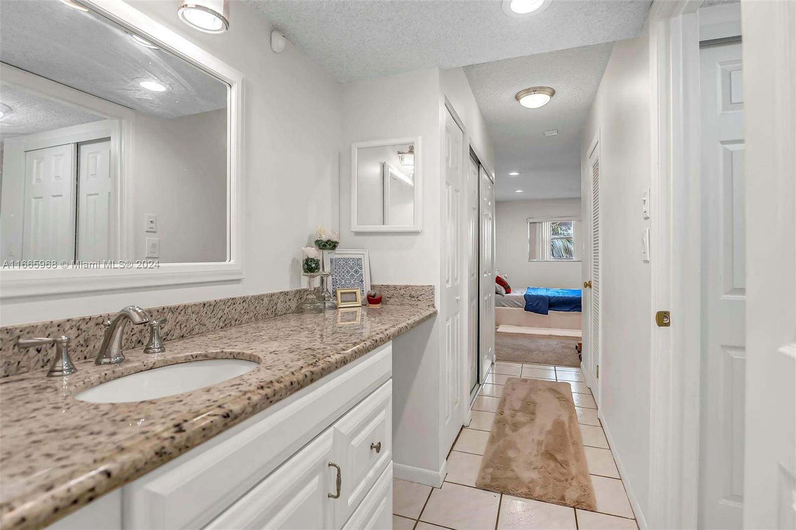 4111 Stirling Road, Unit 304 Fort Lauderdale, FL 33314 - Photo 11 of 22 a bathroom with a granite countertop sink and a mirror