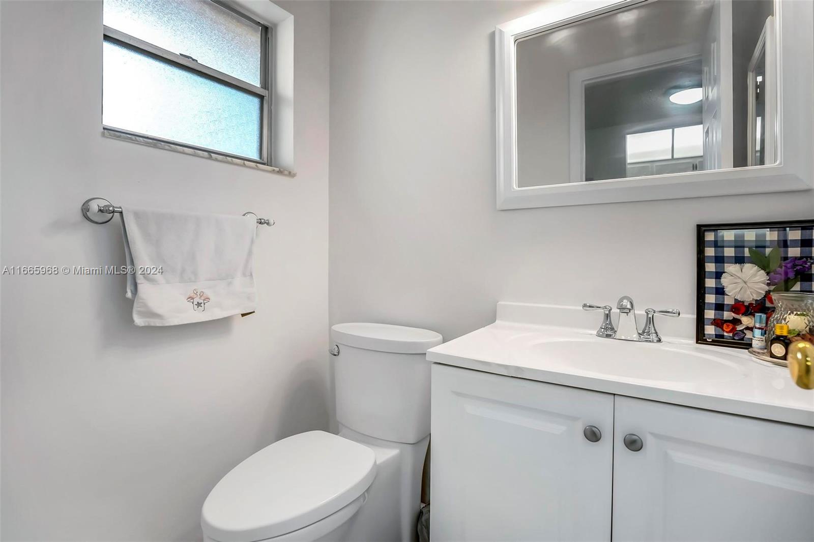 4111 Stirling Road, Unit 304 Fort Lauderdale, FL 33314 - Photo 10 of 22 a bathroom with a sink a toilet and mirror