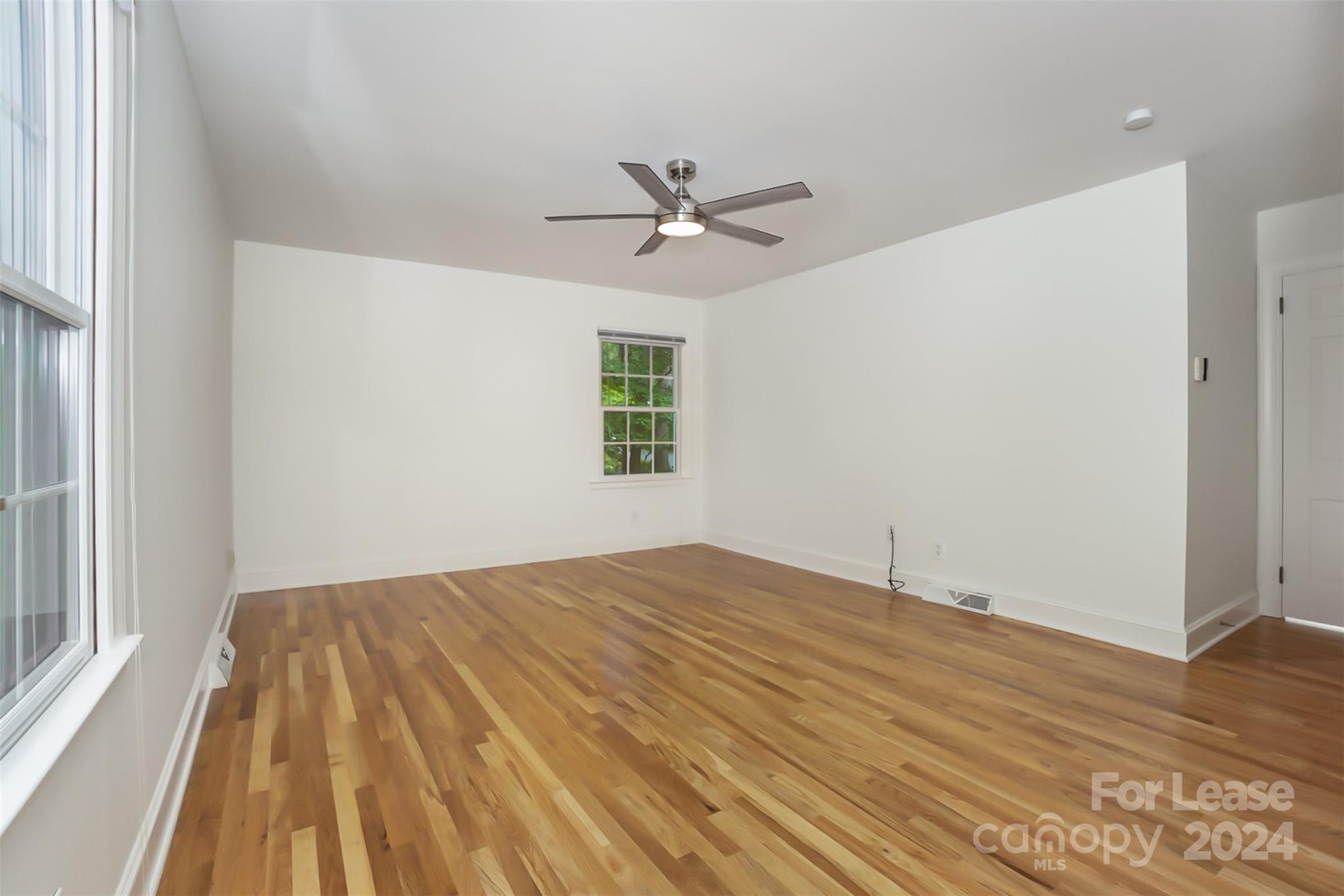 926 Shady Bluff Drive Charlotte, NC 28211 - Photo 21 of 44 an empty room with wooden floor ceiling fan and windows