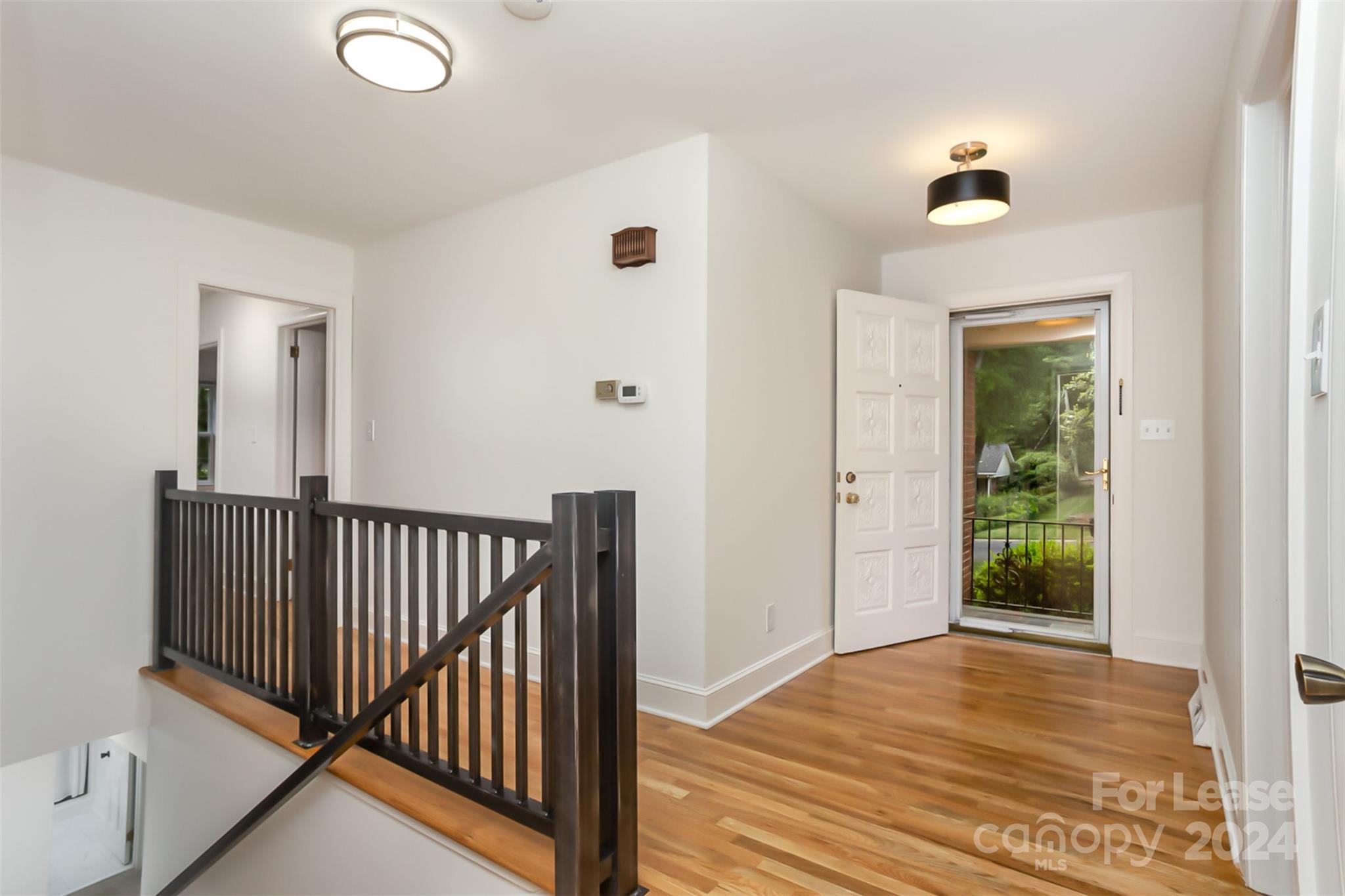 926 Shady Bluff Drive Charlotte, NC 28211 - Photo 6 of 44 a view of a hallway with wooden floor and a chandelier