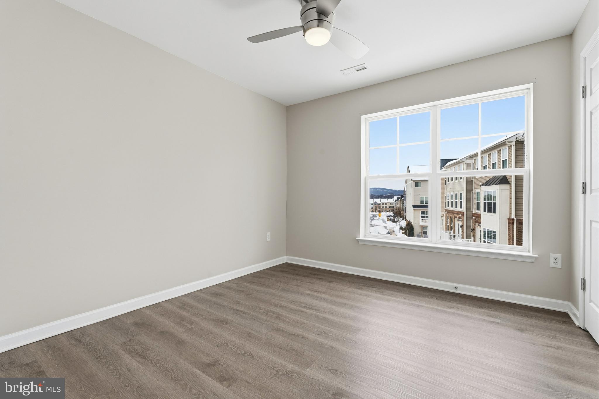5902 Forum Square Frederick, MD 21703 - Photo 11 of 28 an empty room with wooden floor and windows