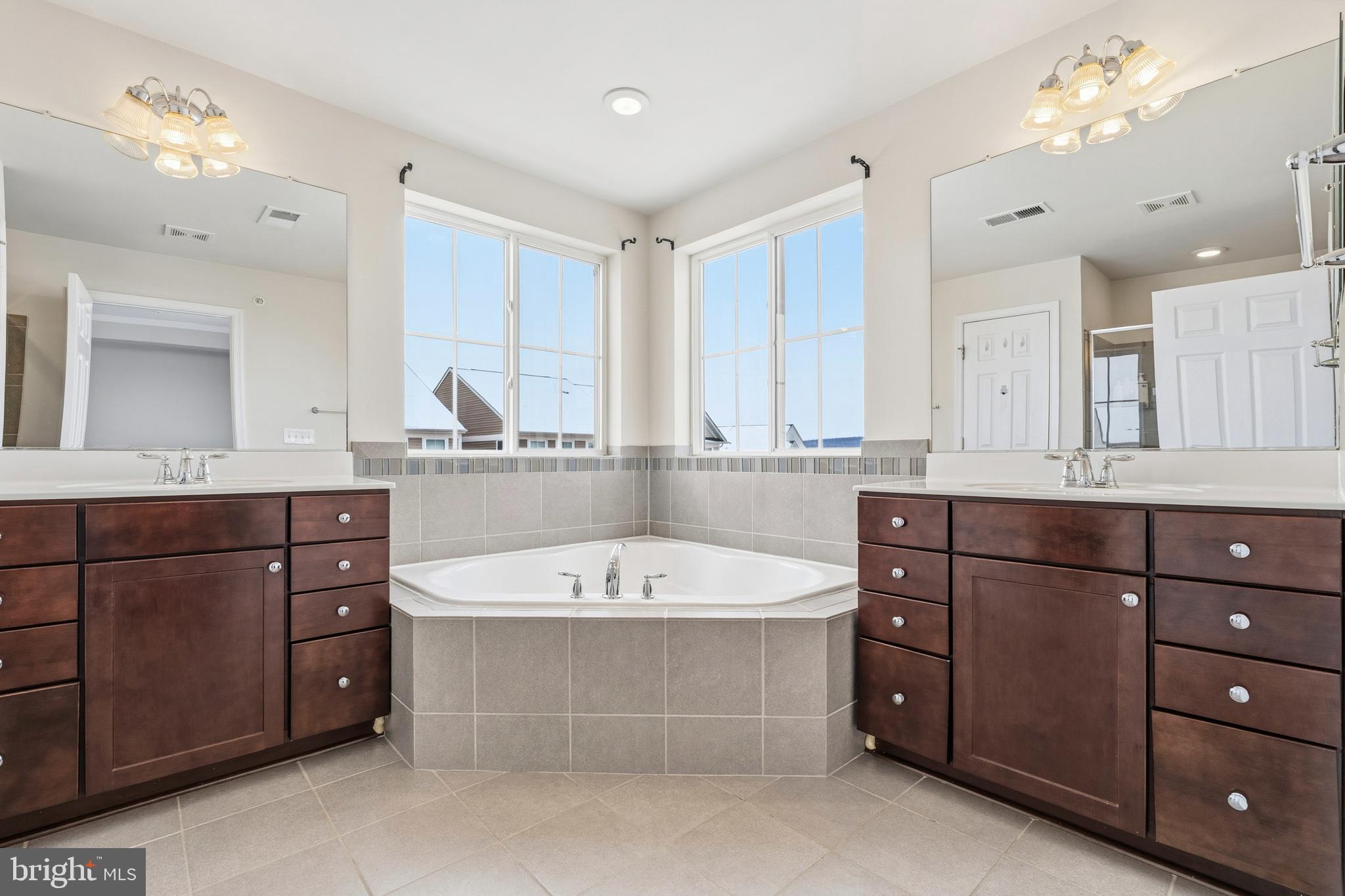 5902 Forum Square Frederick, MD 21703 - Photo 21 of 28 a bathroom with a tub a double vanity sink mirror and