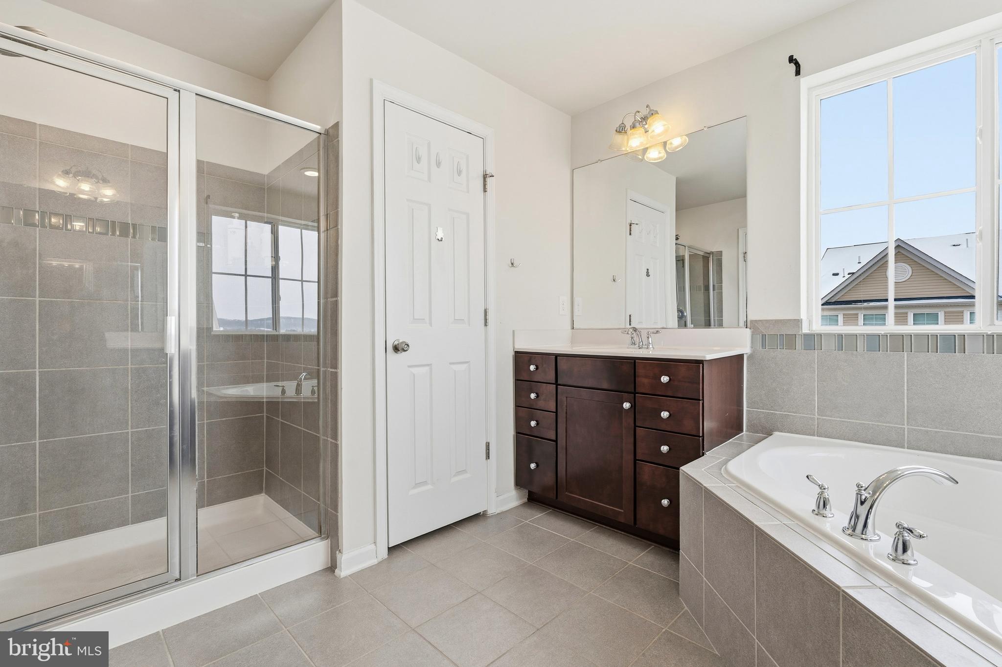 5902 Forum Square Frederick, MD 21703 - Photo 22 of 28 a bathroom with a tub a sink and glass door shower
