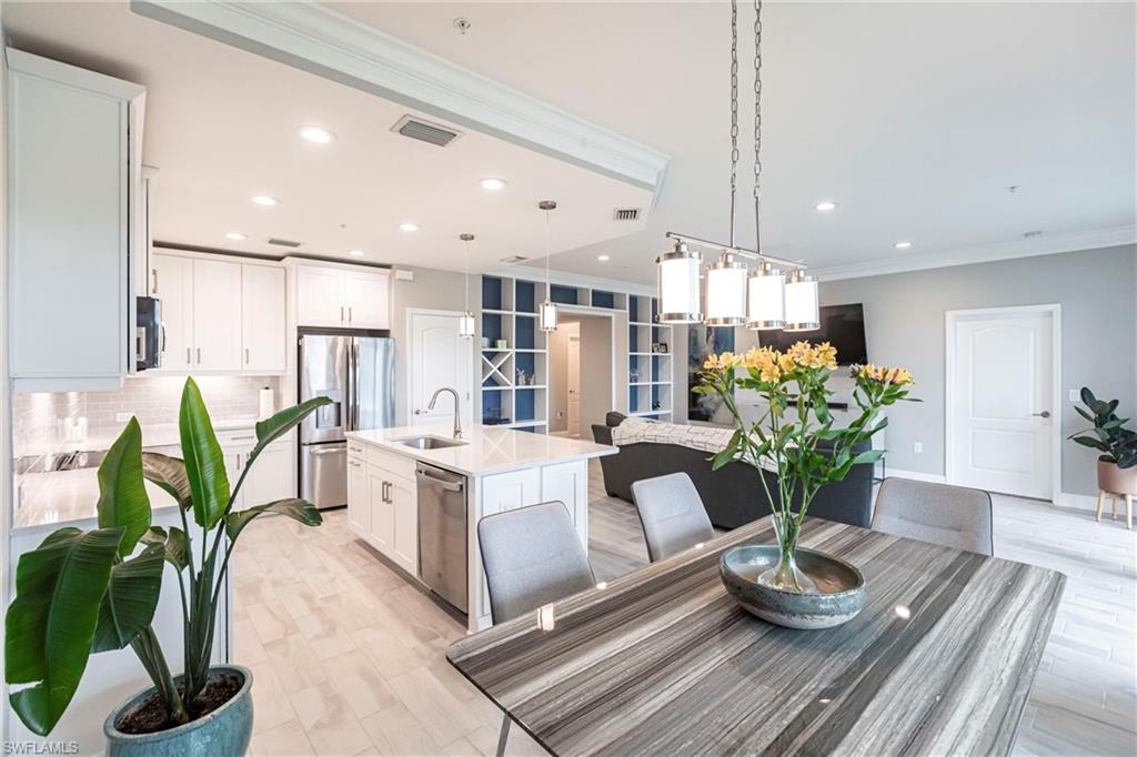 2319 Sawyers Hill Road, Unit 703 Naples, FL 34120 - Photo 13 of 35 a living room with kitchen island furniture and a potted plant