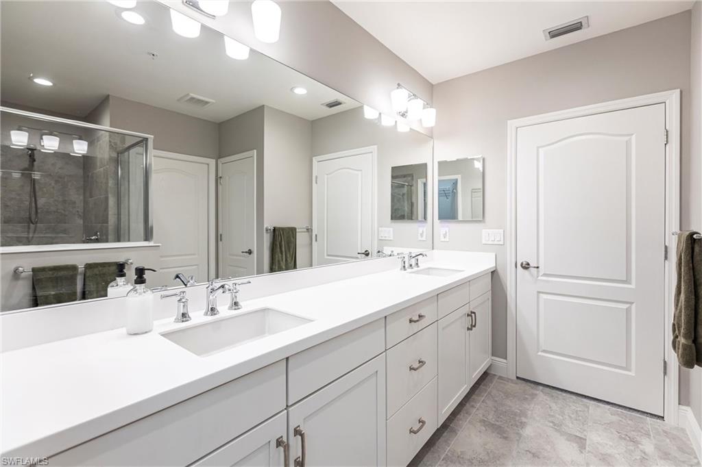 2319 Sawyers Hill Road, Unit 703 Naples, FL 34120 - Photo 20 of 35 a bathroom with a double vanity sink mirror and