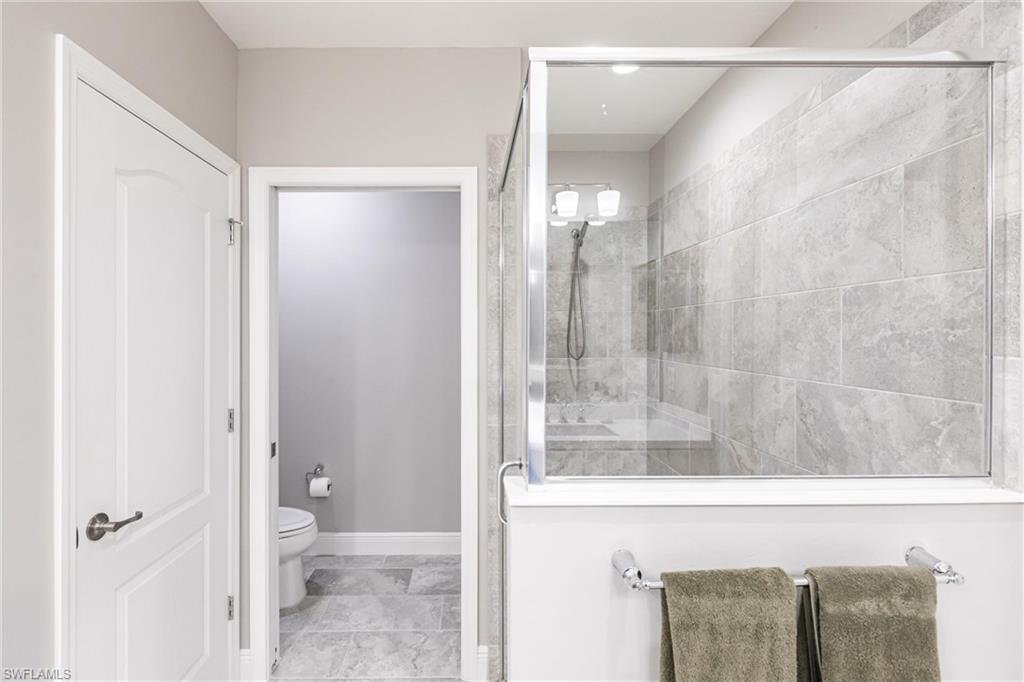 2319 Sawyers Hill Road, Unit 703 Naples, FL 34120 - Photo 21 of 35 a bathroom with a shower and a toilet