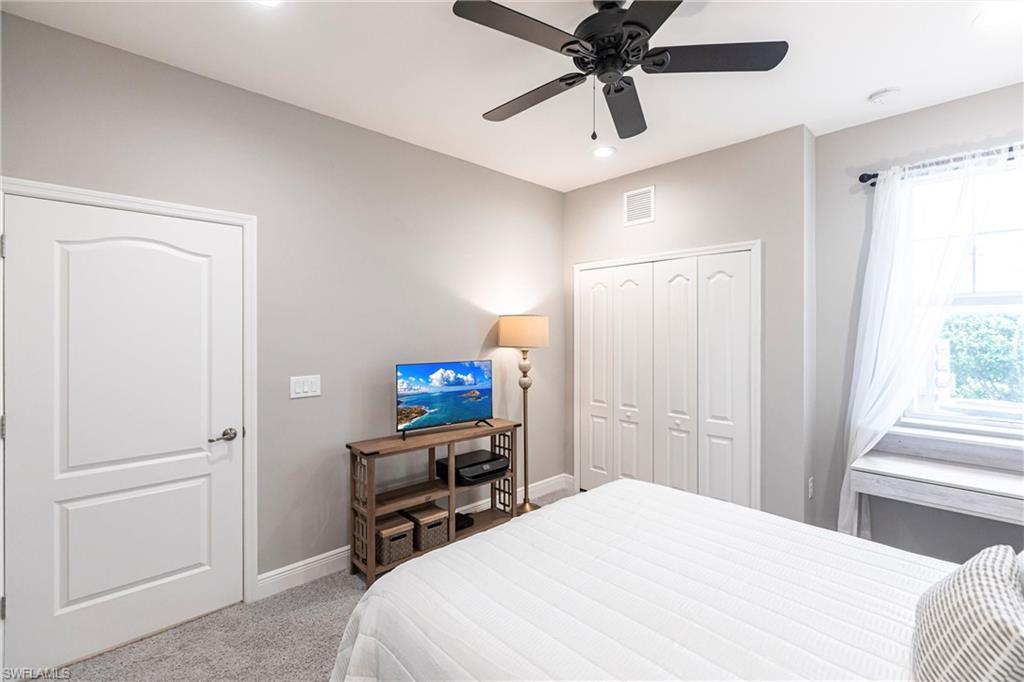 2319 Sawyers Hill Road, Unit 703 Naples, FL 34120 - Photo 25 of 35 a bedroom with a bed and a tv on the dresser