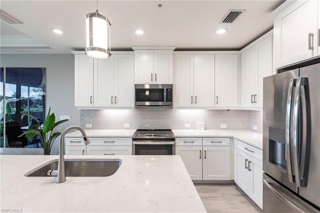 2319 Sawyers Hill Road, Unit 703 Naples, FL 34120 - Photo 9 of 35 a kitchen with a refrigerator and a sink