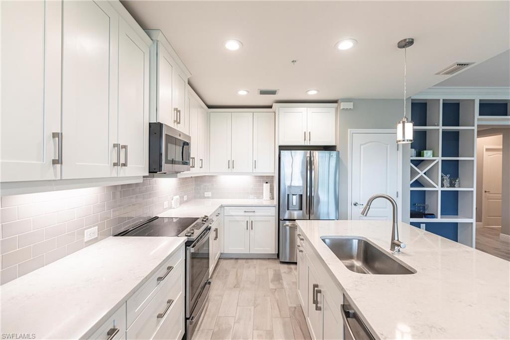 2319 Sawyers Hill Road, Unit 703 Naples, FL 34120 - Photo 10 of 35 a kitchen with a sink stove and cabinets