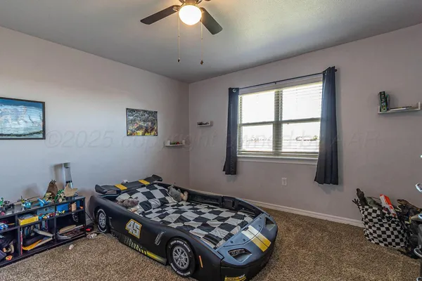 a bedroom with a bed and a chandelier fan
