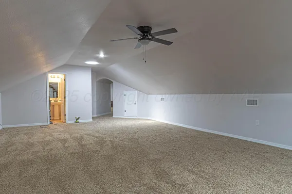 a view of an empty room with a ceiling fan