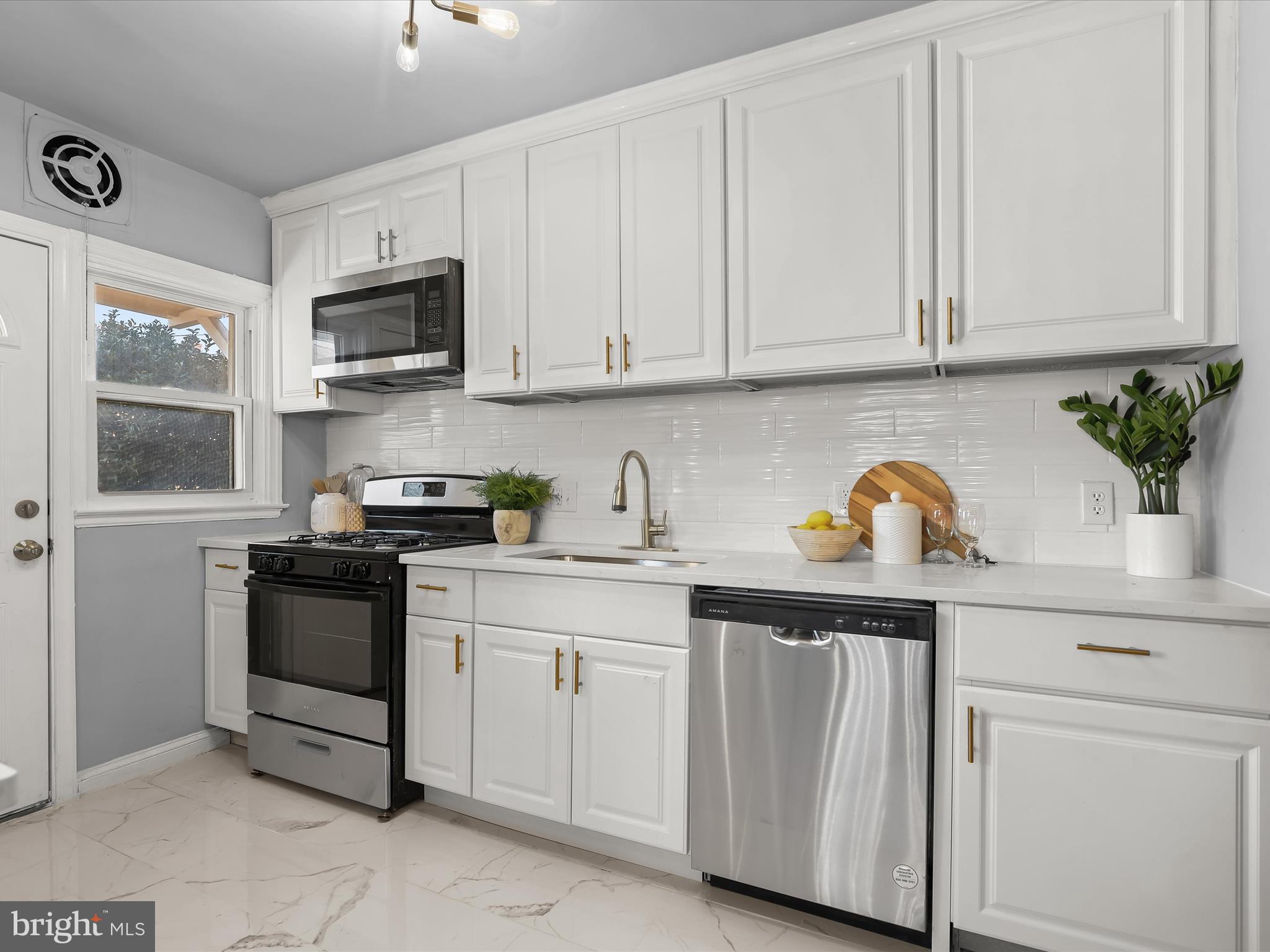 1350 Pentwood Road Baltimore, MD 21239 - Photo 14 of 37 a kitchen with white cabinets and appliances