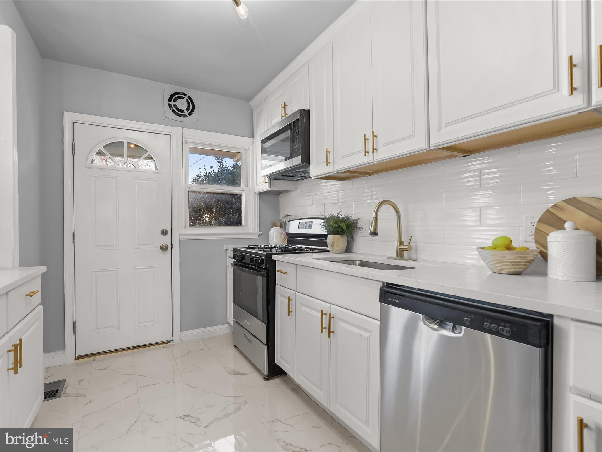 1350 Pentwood Road Baltimore, MD 21239 - Photo 16 of 37 a kitchen with stainless steel appliances granite countertop a sink stove and cabinets