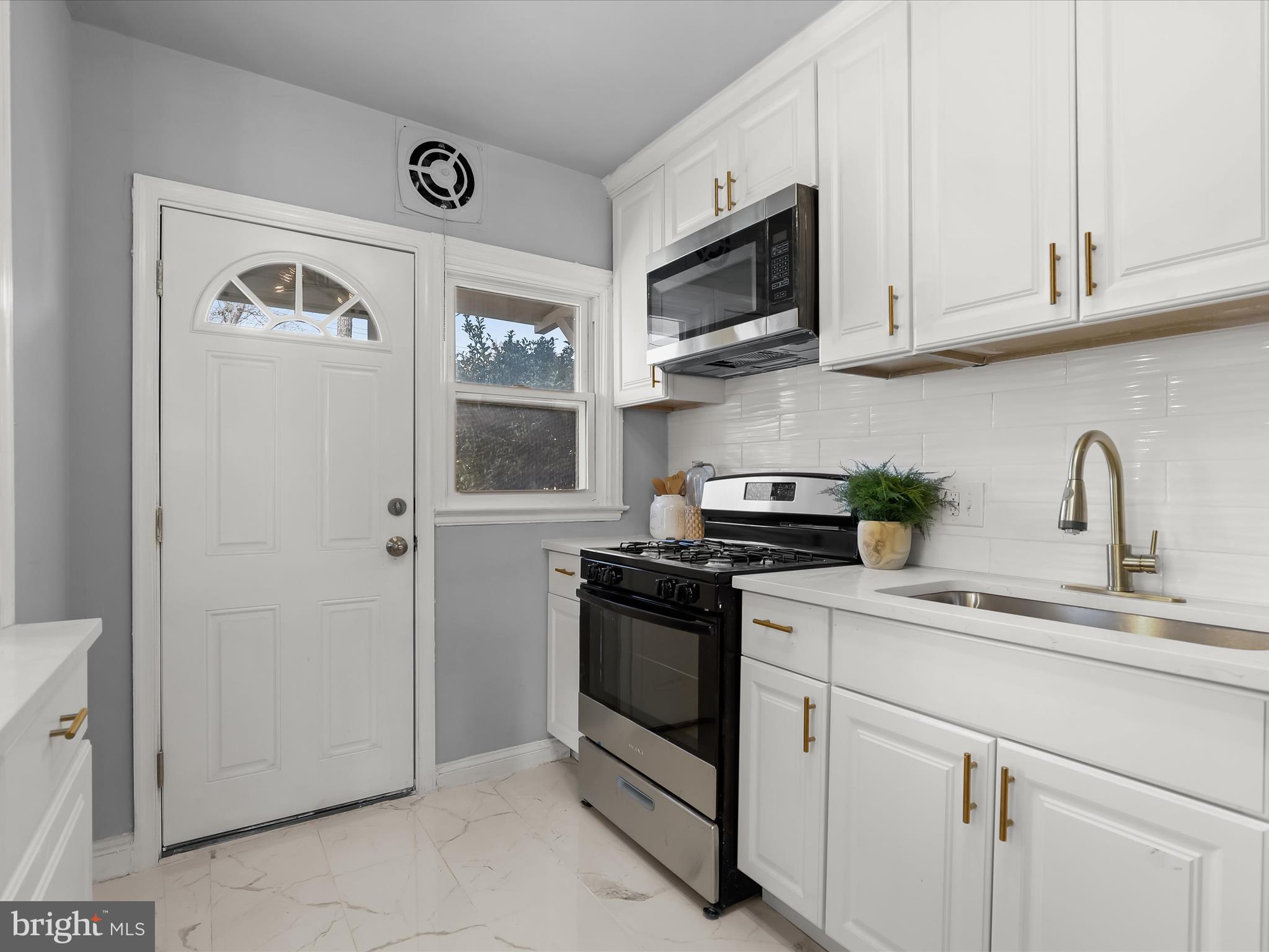1350 Pentwood Road Baltimore, MD 21239 - Photo 18 of 37 a kitchen with stainless steel appliances granite countertop white cabinets and a sink