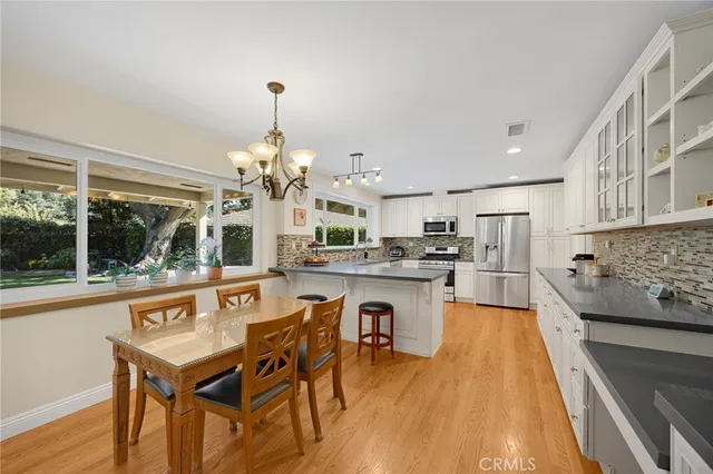 a kitchen with a table chairs stove and refrigerator