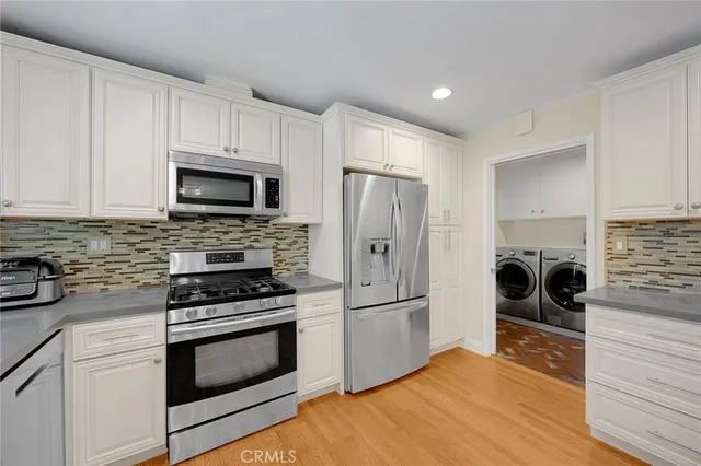 a kitchen with a refrigerator stove and white cabinets