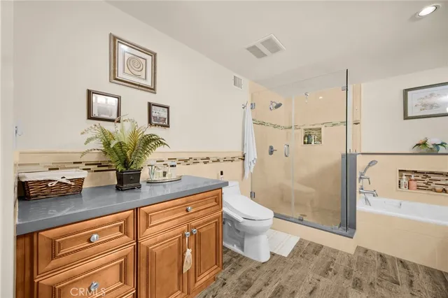 a bathroom with a granite countertop sink a toilet and shower