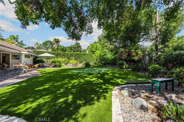 a view of backyard with outdoor seating and green space