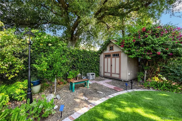 a backyard of a house with table and chairs and a large tree