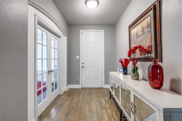 a view of hallway with wooden floor and fan
