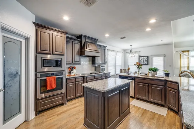 a large kitchen with stainless steel appliances granite countertop a stove and a sink