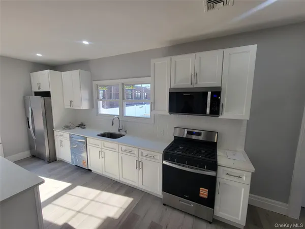 a kitchen with stainless steel appliances granite countertop a stove a sink a refrigerator and a microwave