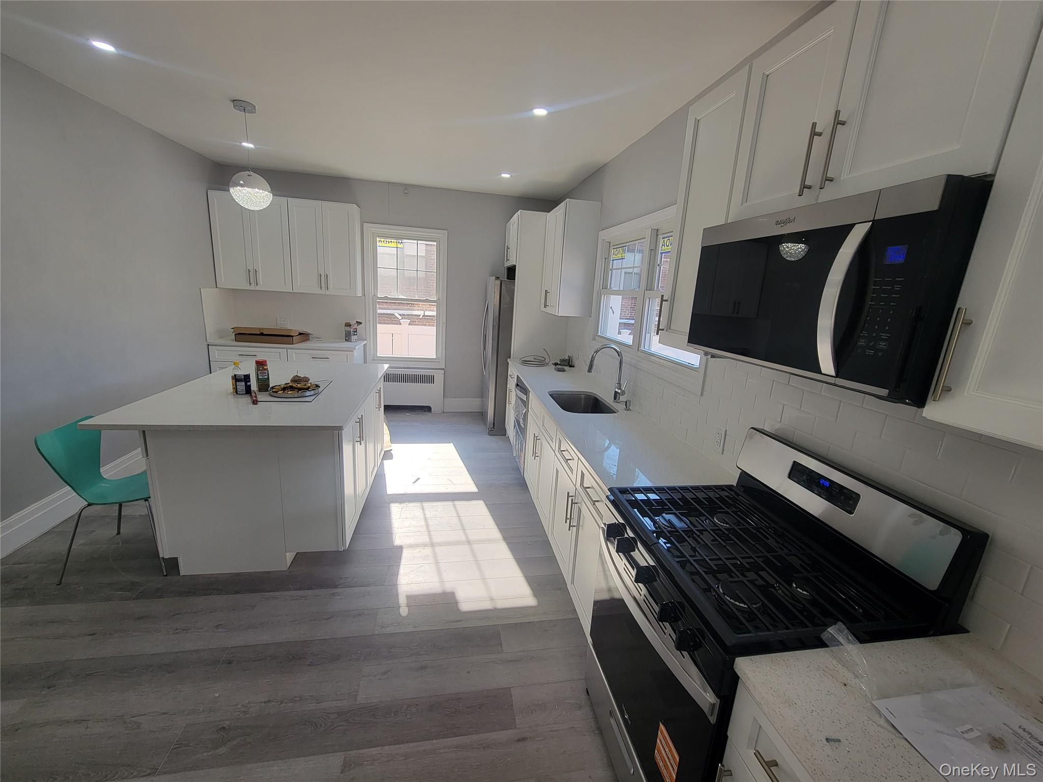 315 Mill Road Hewlett, NY 11557 - Photo 12 of 12 a kitchen with stainless steel appliances granite countertop a stove a sink a refrigerator and a microwave