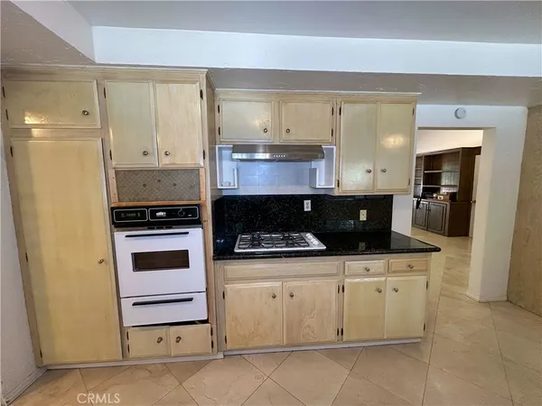 a kitchen with white cabinets and appliances